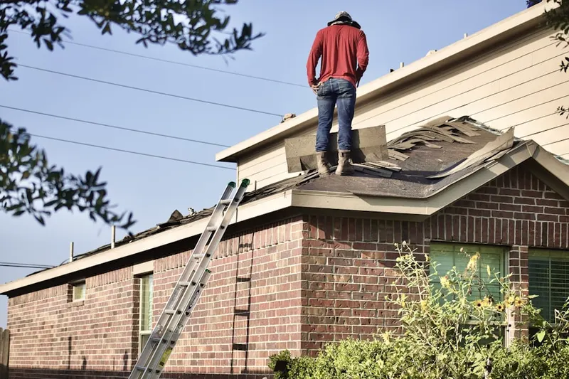 Professional roofer working on a residential roof in West Enola